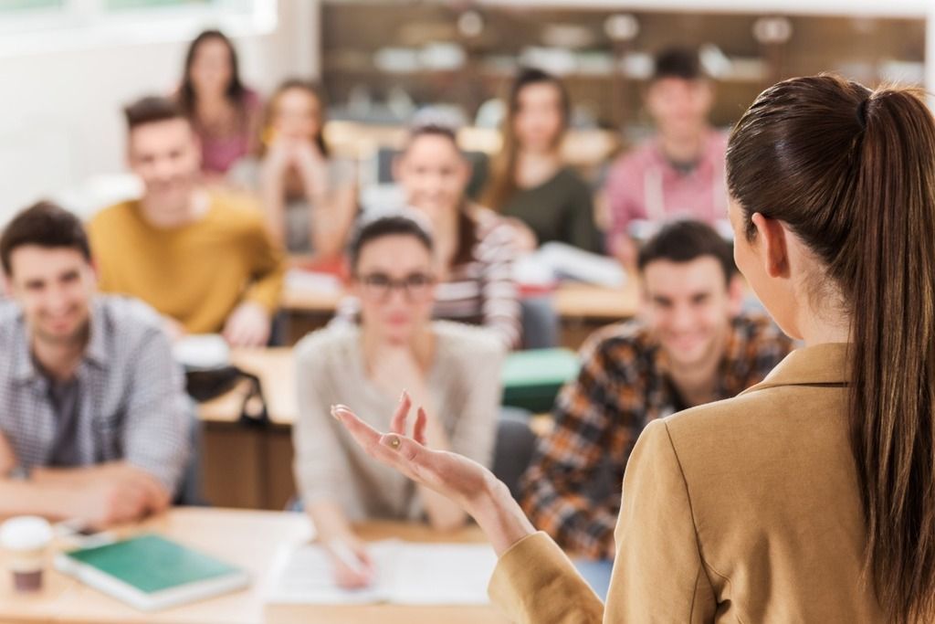 Female teacher classroom students debriefing