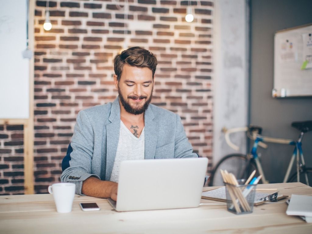 man behind a laptop in a modern office