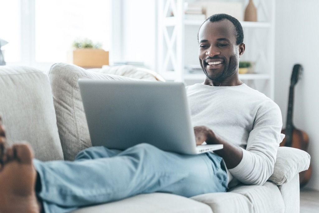 man on a sofa with laptop