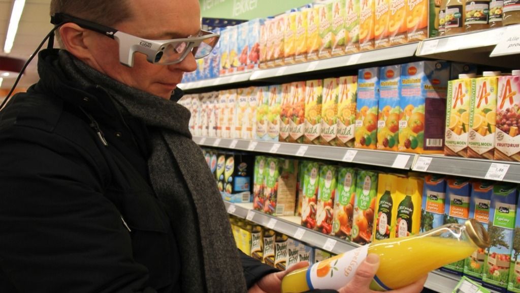 man supermarket holding juice with eyetracking glasses