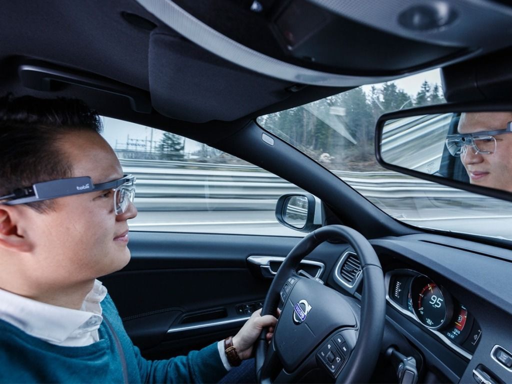 man with tobii eye tracking glasses driving in a car