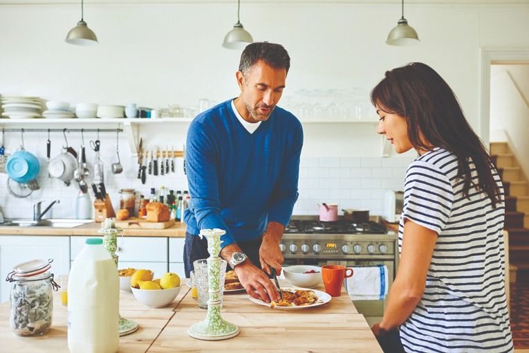 man woman cooking eating kitchen