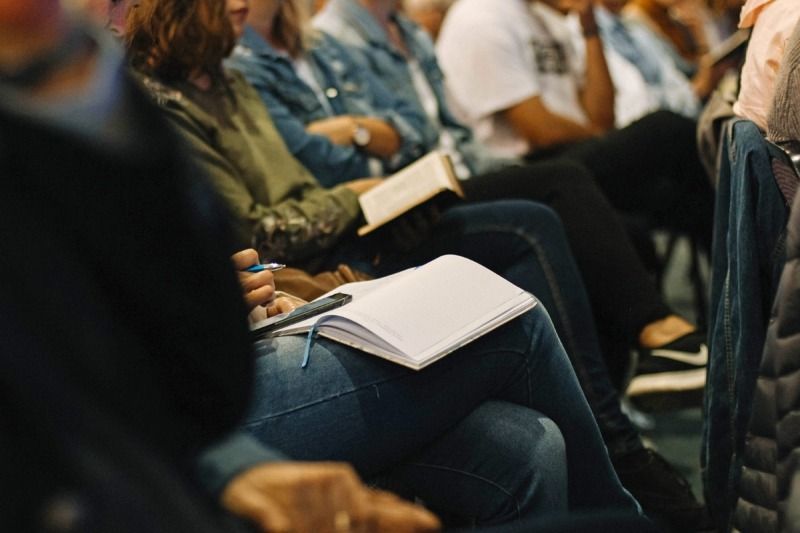 people conference taking notes book