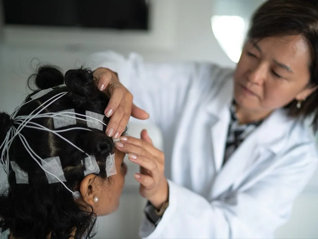 Doctor putting on EEG sensors