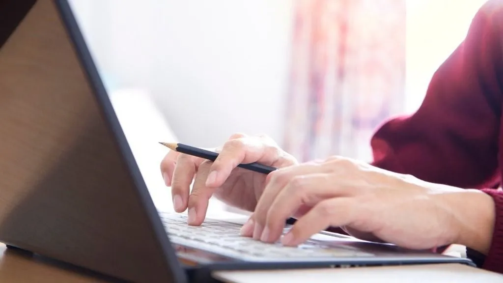 hands typing laptop