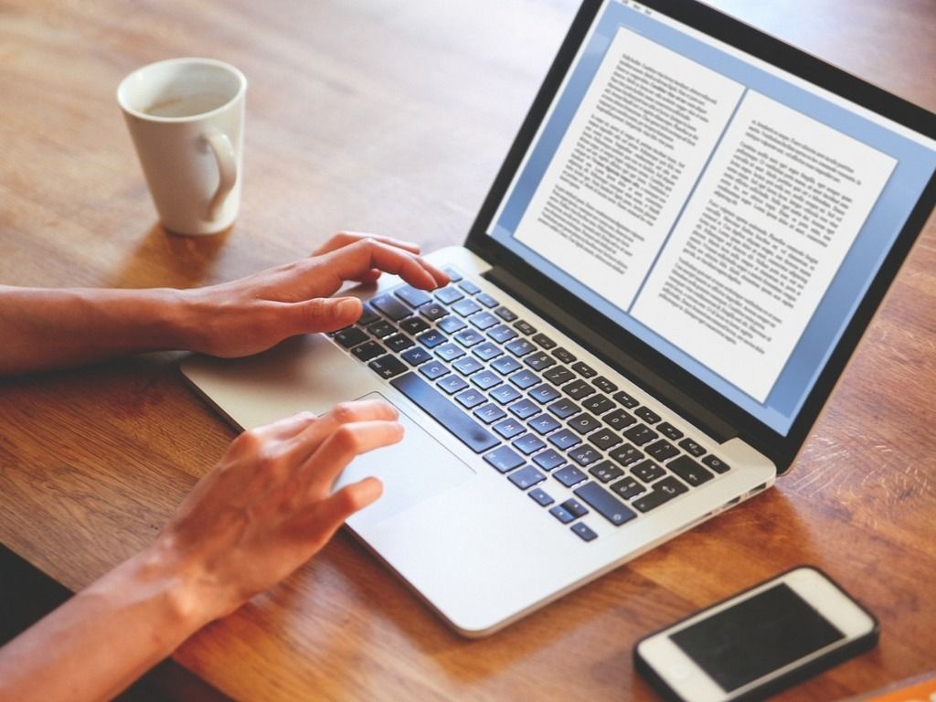 Hands typing on a laptop