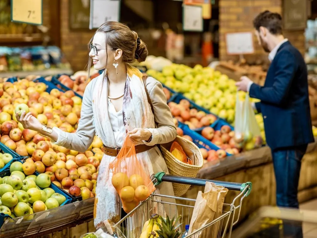 Woman and man in supermarket looking at fruit