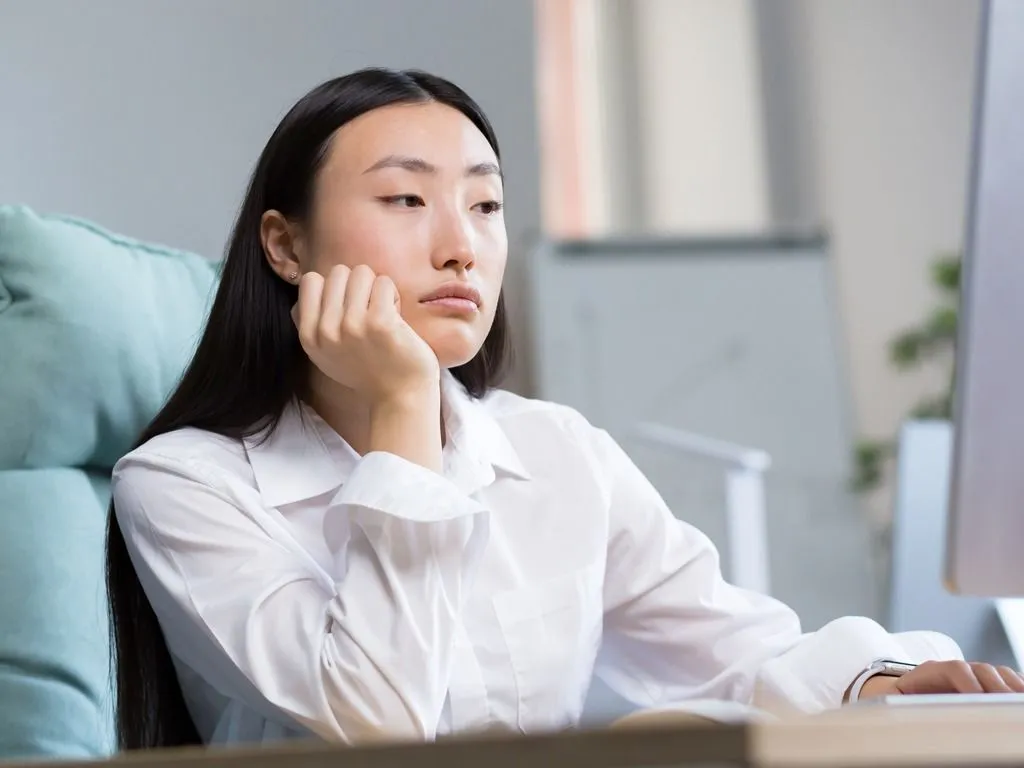 Woman at desk looking bored