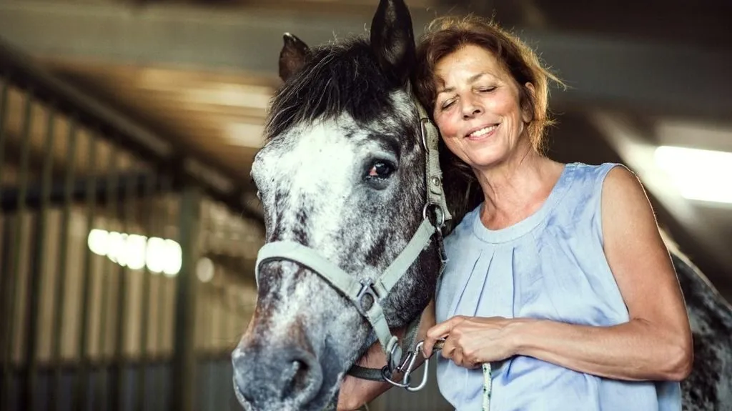 Woman cuddling a hors